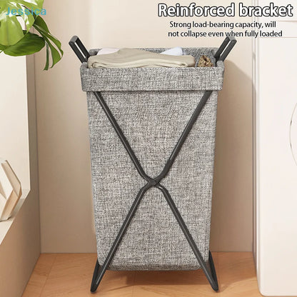 Collapsible fabric laundry hamper with handles in bedroom setting